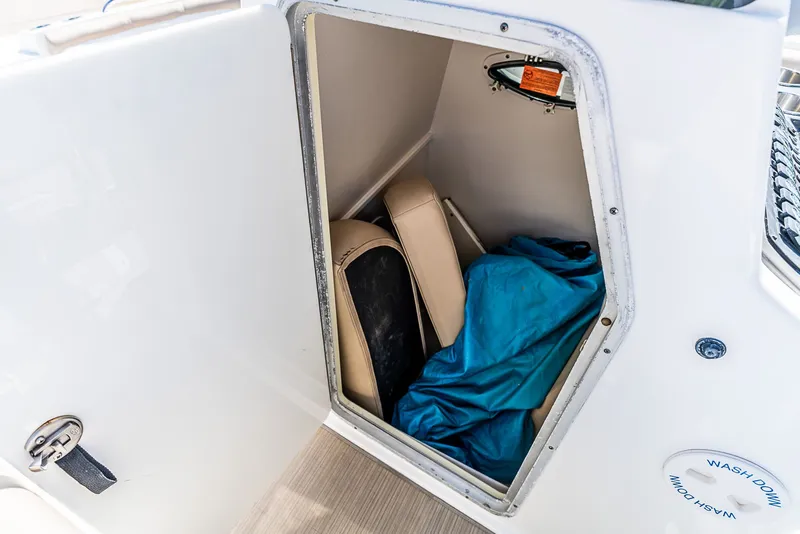 Slide: The Image of A storage compartment on a boat with cushions and a blue tarp. - 10