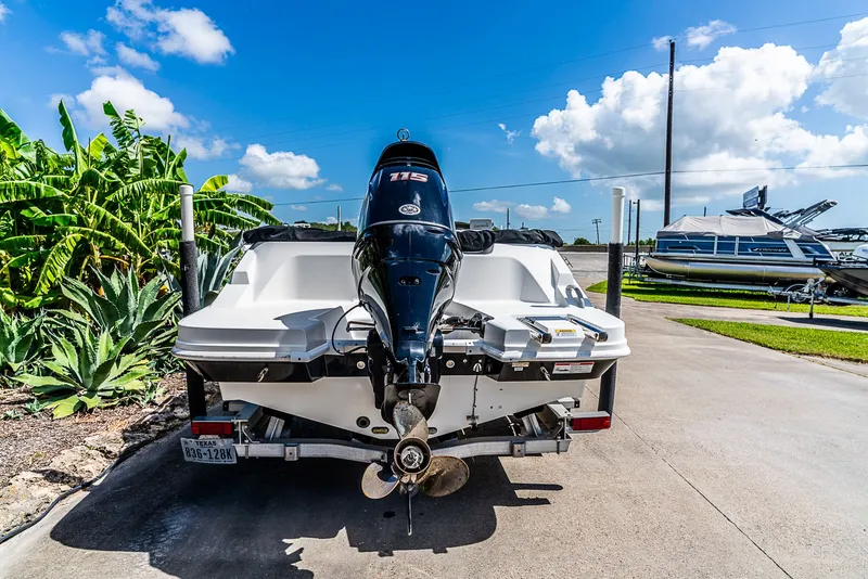 Slide: The Image of A 2020 Hurricane SS185 boat on a trailer, surrounded by plants and a blue sky. - 4