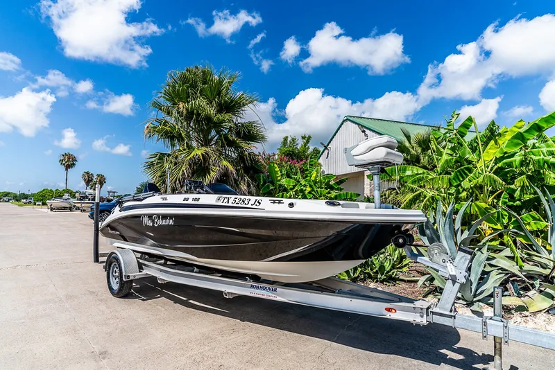 The Image of A 2020 Hurricane SS185 boat on a trailer, surrounded by palm trees and a blue sky. - 1