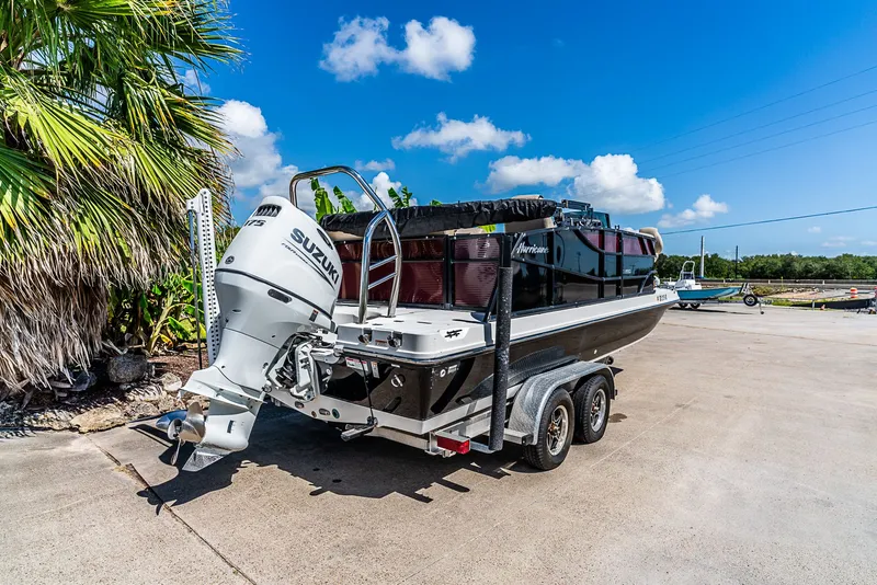 Slide: The Image of A 2022 Hurricane FD2260F boat on a trailer, featuring a Suzuki outboard motor. - 3