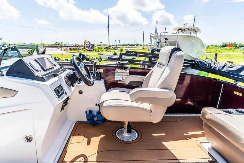 Slide: The Image of 2022 Hurricane FD2260F with beige captain's chair and modern dashboard on a wooden deck. - 10