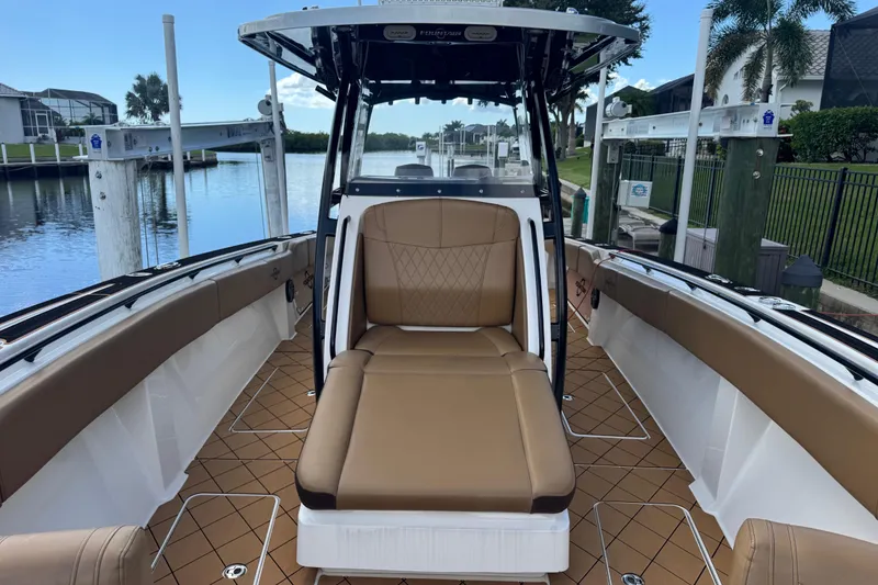 Slide: The Image of 2020 Fountain 38 Center Console boat with tan seating, docked by a waterfront. - 20