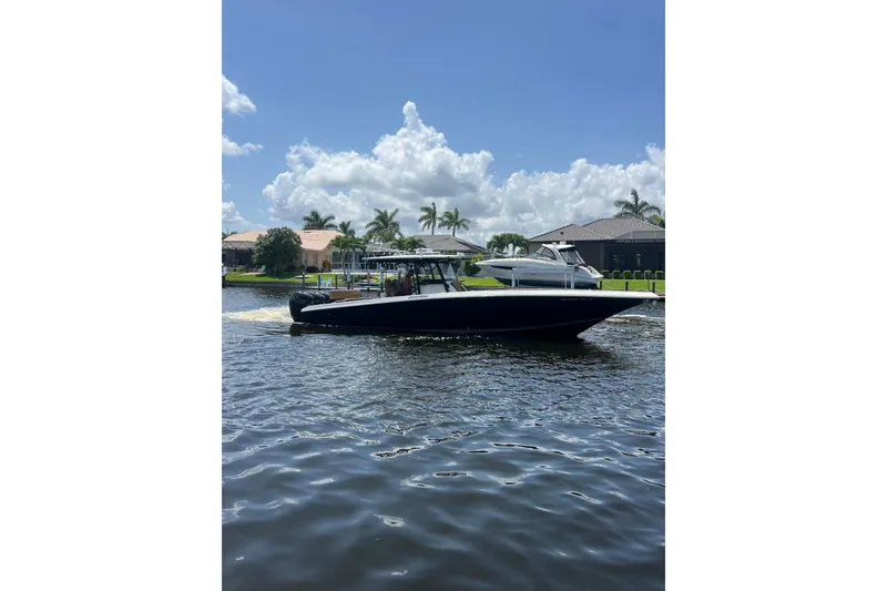 Slide: The Image of 2020 Fountain 38 Center Console boat cruising on a sunny day with palm trees in the background. - 3