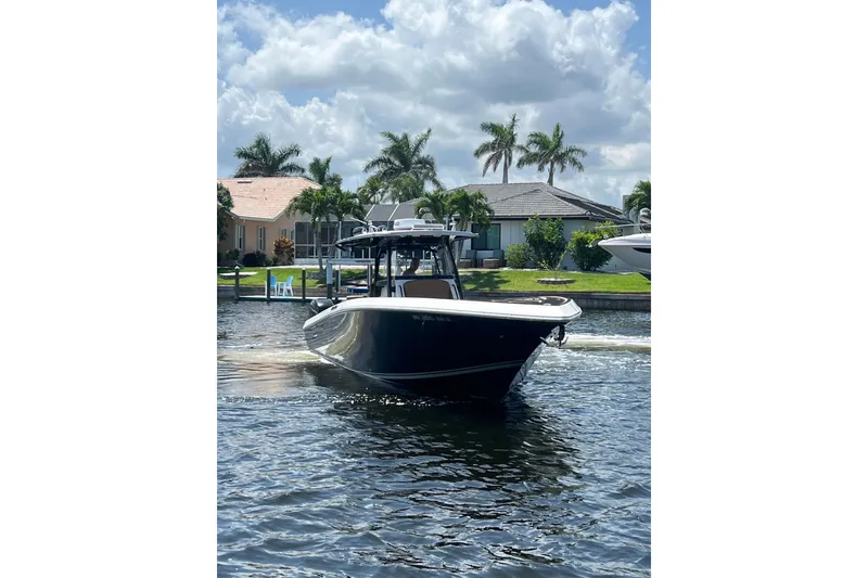 Slide: The Image of 2020 Fountain 38 Center Console boat cruising on a sunny day with palm trees in the background. - 4