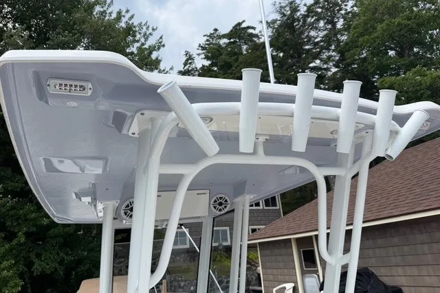 Slide: The Image of 2026 Robalo R270 Center Console boat with rod holders and T-top against a wooded backdrop. - 10