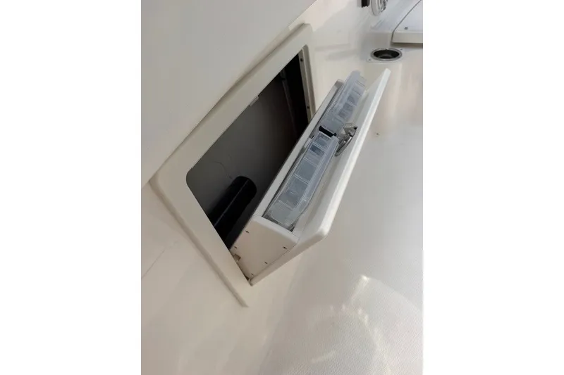 Slide: The Image of 2026 Robalo R270 Center Console storage compartment with open hatch and organized interior. - 34