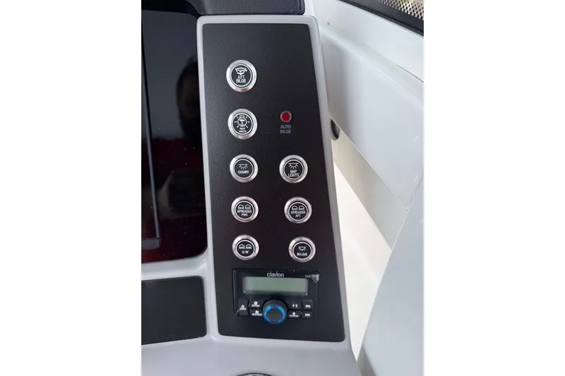 Slide: The Image of Control panel of 2026 Robalo R270 Center Console boat with various switches and Clarion audio system. - 23