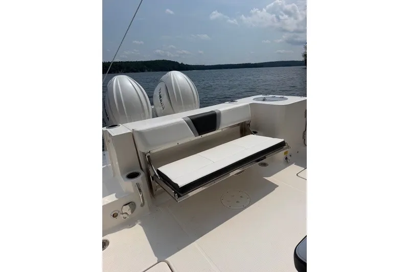 Slide: The Image of 2026 Robalo R270 Center Console boat with foldable seating, on a serene lake. - 13
