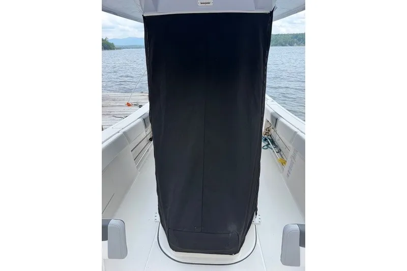 Slide: The Image of 2026 Robalo R270 Center Console boat interior with covered console, docked by the water. - 6