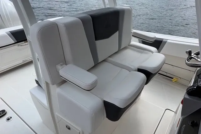 Slide: The Image of 2026 Robalo R270 Center Console boat interior with plush seating and ocean backdrop. - 15
