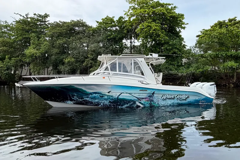 Slide: The Image of 2010 Hydra-Sports 3500 VX boat with vibrant ocean-themed graphics on a calm waterway. - 0