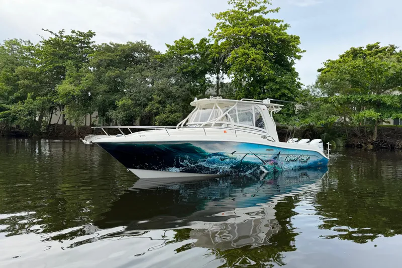 Slide: The Image of 2010 Hydra-Sports 3500 VX boat on calm water, surrounded by lush greenery. - 3