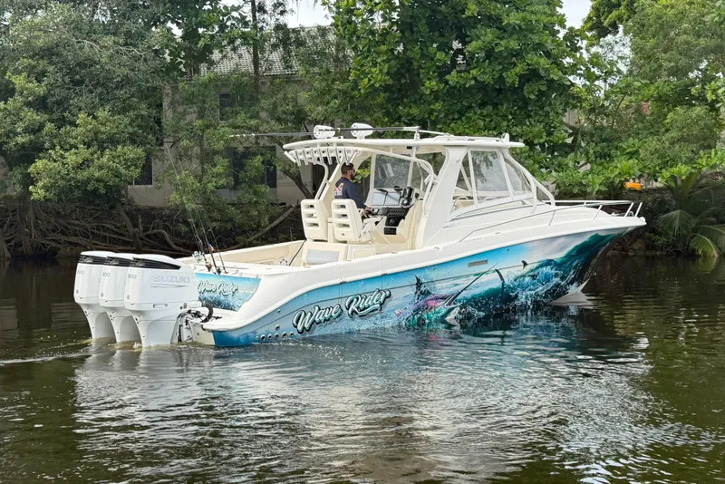 Slide: The Image of 2010 Hydra-Sports 3500 VX boat with vibrant marine graphics on a calm river. - 6