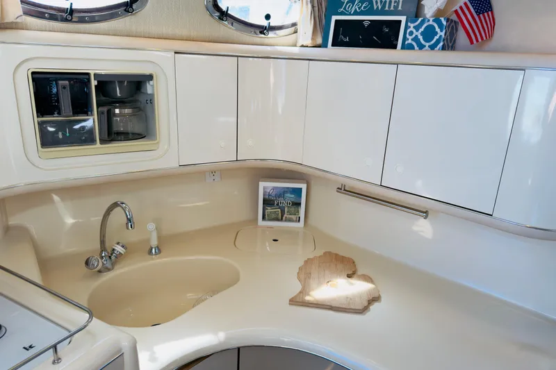 Slide: The Image of 1995 Sea Ray Sundancer 370 yacht kitchen with sink, cabinets, and decor items. - 14