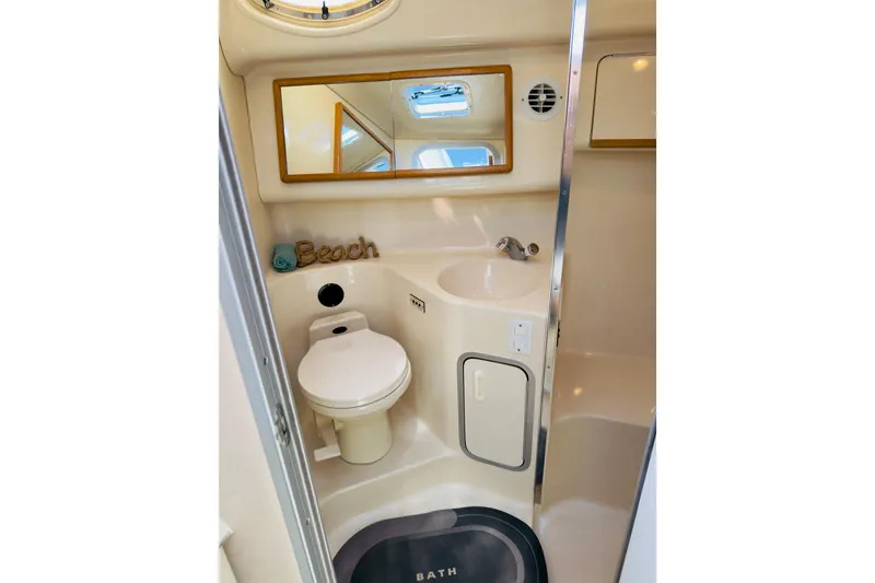 Slide: The Image of Bathroom interior of 1995 Sea Ray Sundancer 370 yacht, featuring toilet, sink, and mirror. - 19