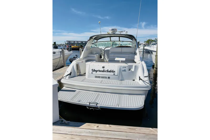 Slide: The Image of 1995 Sea Ray Sundancer 370 docked at marina, rear view with "Unpredictable" nameplate. - 5