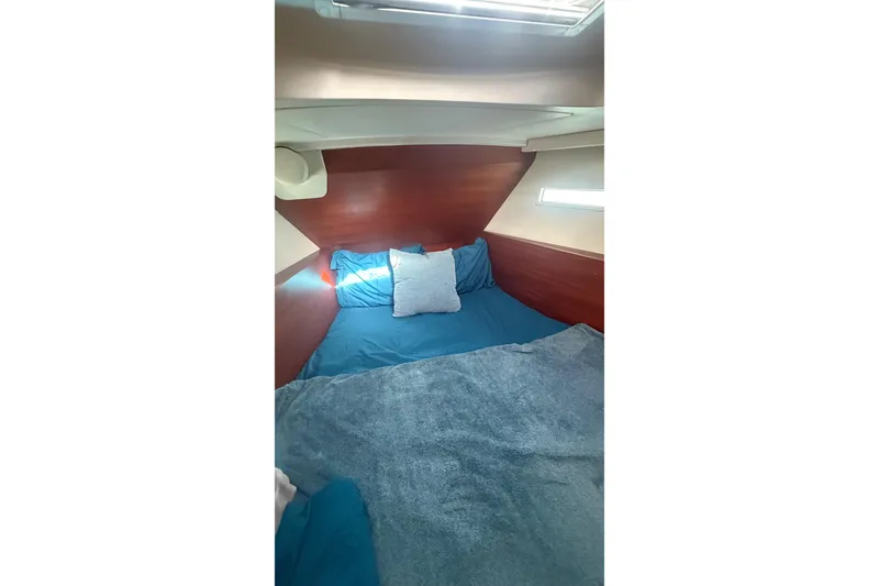 Slide: The Image of Cozy cabin interior of 2015 Salona 44 yacht with blue bedding and wooden accents. - 20