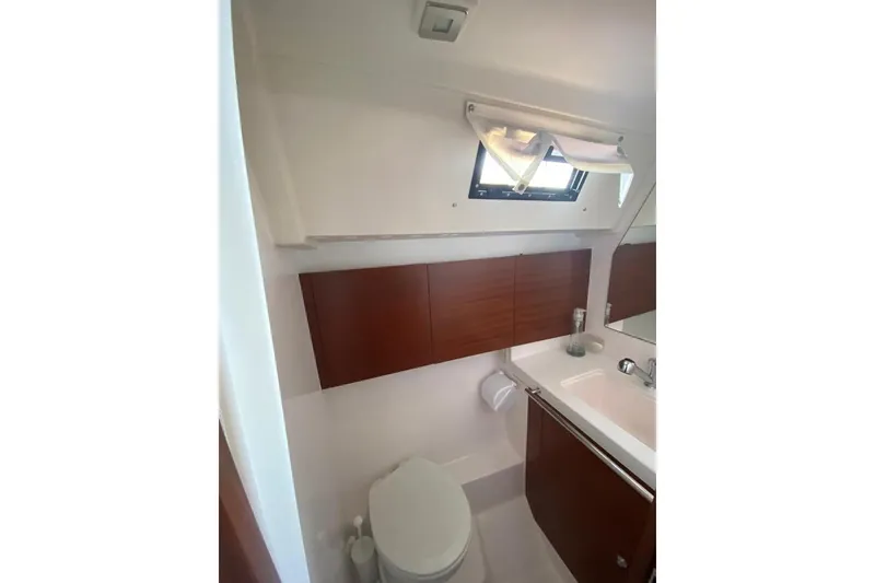 Slide: The Image of 2015 Salona 44 yacht bathroom with wooden cabinets and a small window. - 7