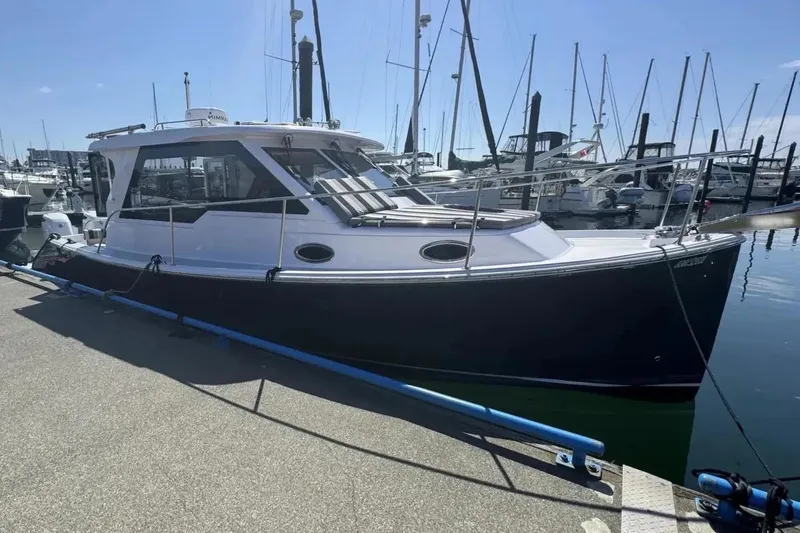 The Image of 2022 True North 34 Outboard Express docked at a marina, surrounded by sailboats. - 1