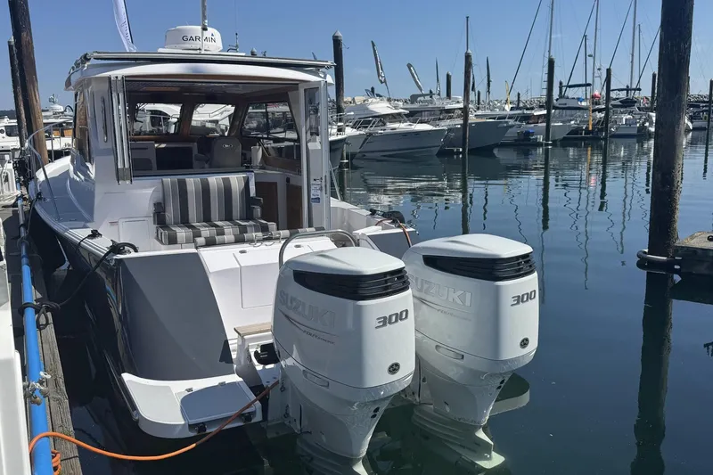 Slide: The Image of 2022 True North 34 Outboard Express boat docked with twin Suzuki 300 engines. - 2