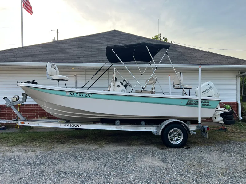 The Image of A Carolina Skiff 192 JLS boat on a trailer in front of a garage. - 0