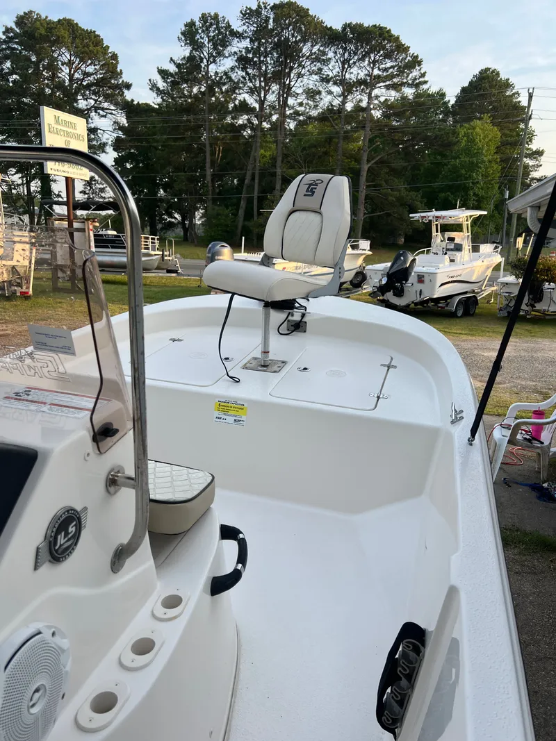 Slide: The Image of A white boat with a seat and console, surrounded by trees and other boats. - 4