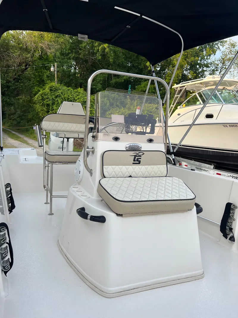 Slide: The Image of A Carolina Skiff 192 JLS boat with cushioned seats and a black sunshade. - 5