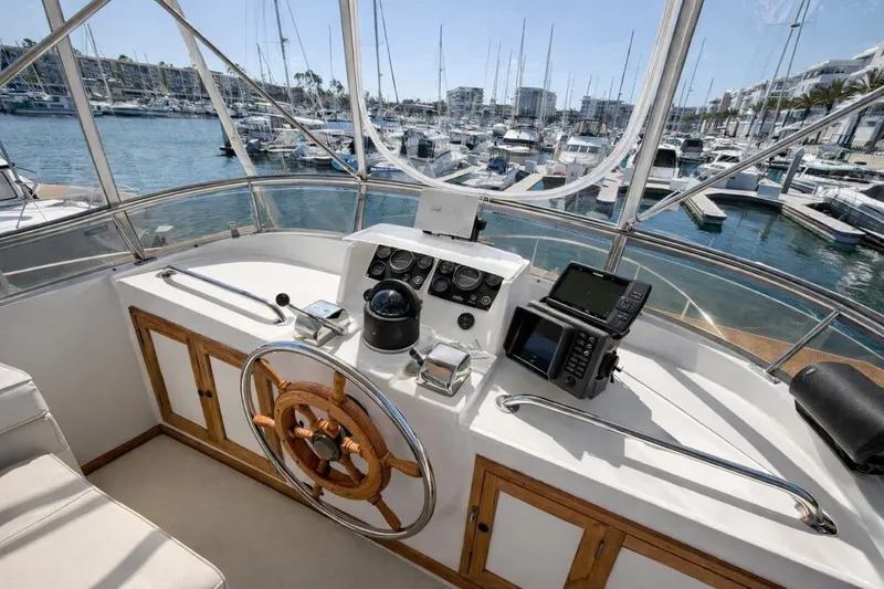 Slide: The Image of Helm of 1987 Fair Weather Mariner 38 yacht in marina, featuring navigation equipment and wooden wheel. - 14
