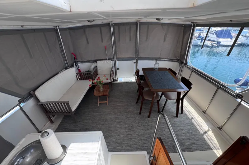 Slide: The Image of Interior of 1987 Fair Weather Mariner 38 with seating, table, and marina view. - 19