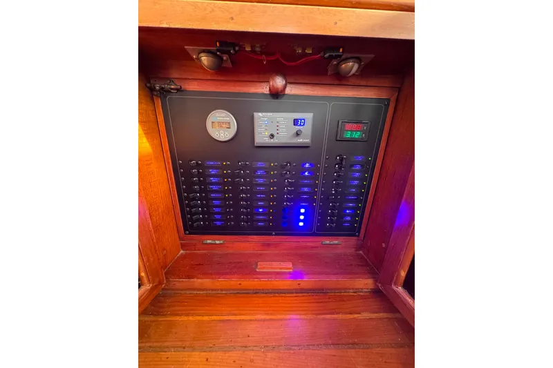 Slide: The Image of Electrical panel of a 1987 Fair Weather Mariner 38 boat with illuminated switches. - 17