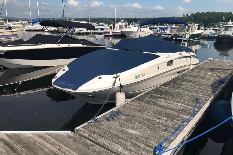 Slide: The Image of 2013 Sea Ray 260 Sundeck boat docked at a marina with blue cover. - 1