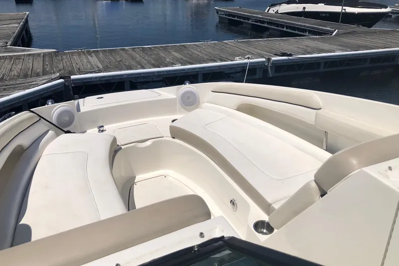 Slide: The Image of 2013 Sea Ray 260 Sundeck boat interior with white seating at marina. - 13