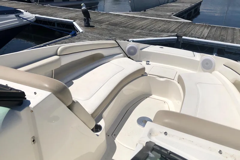 Slide: The Image of 2013 Sea Ray 260 Sundeck boat interior with beige seating at a dock. - 14