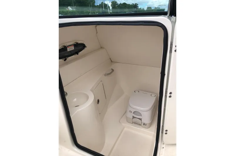 Slide: The Image of 2013 Sea Ray 260 Sundeck interior with compact marine toilet and sink. - 15