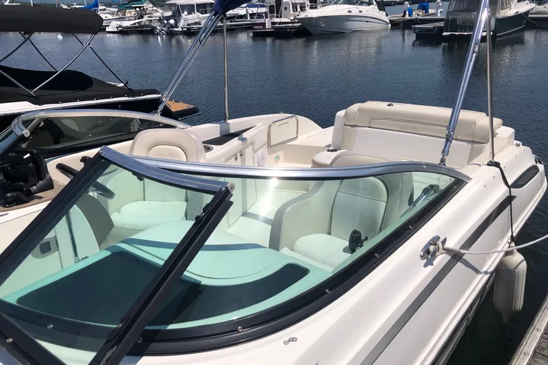 Slide: The Image of 2013 Sea Ray 260 Sundeck boat docked at marina, featuring spacious seating and sleek design. - 4