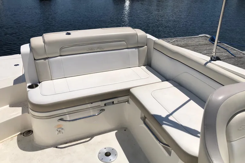 Slide: The Image of 2013 Sea Ray 260 Sundeck boat seating area with beige upholstery by the water. - 8
