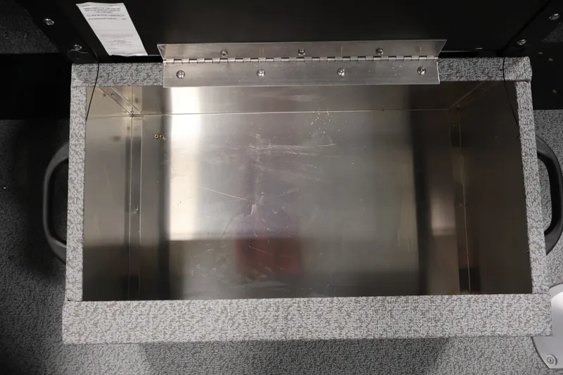 Slide: The Image of Open storage compartment in 2026 Crestliner 1850 Commander boat, featuring metal interior and hinge. - 25