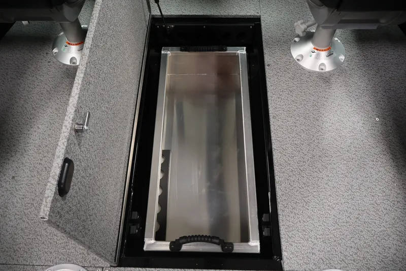 Slide: The Image of 2026 Crestliner 1850 Commander boat storage compartment with open hatch, gray interior. - 22