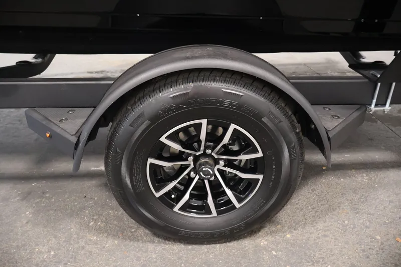 Slide: The Image of Trailer wheel of 2026 Crestliner 1850 Commander boat, featuring black alloy rim. - 36