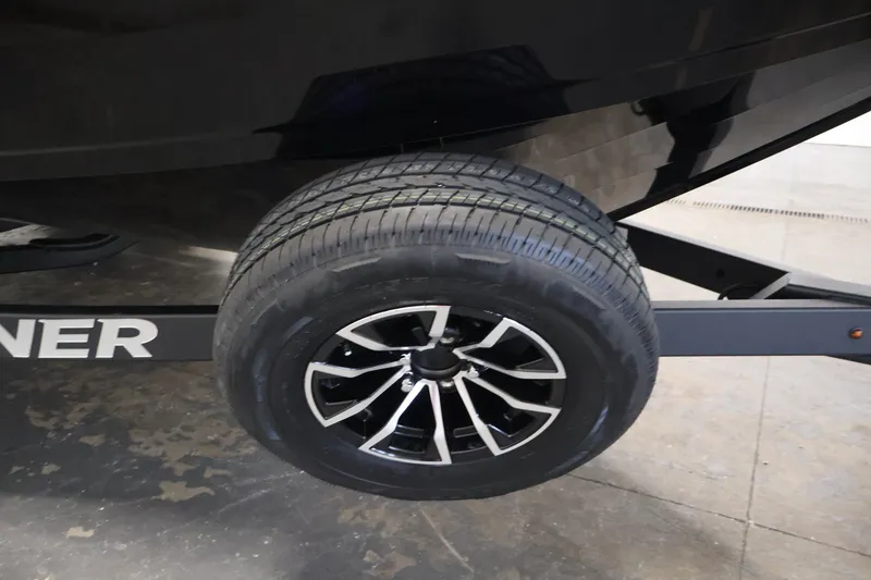 Slide: The Image of Trailer wheel of 2026 Crestliner 2050 Sportfish boat, featuring sleek black and silver design. - 39