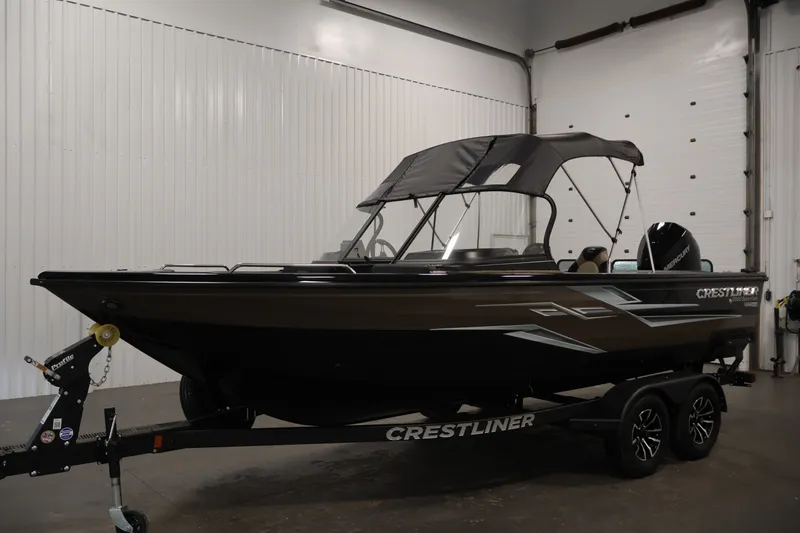 Slide: The Image of 2026 Crestliner 2050 Sportfish boat in a showroom, featuring a sleek design and canopy. - 42