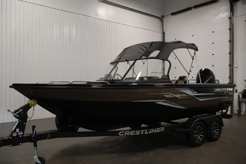 Slide: The Image of 2026 Crestliner 2050 Sportfish boat in indoor showroom, featuring sleek design and trailer. - 41