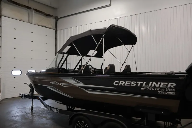 Slide: The Image of 2026 Crestliner 2050 Sportfish boat in indoor storage, featuring sleek design and canopy. - 43