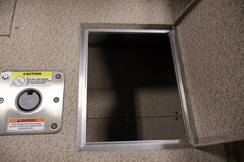 Slide: The Image of 2026 Crestliner 2050 Sportfish boat storage compartment with caution and warning labels. - 31