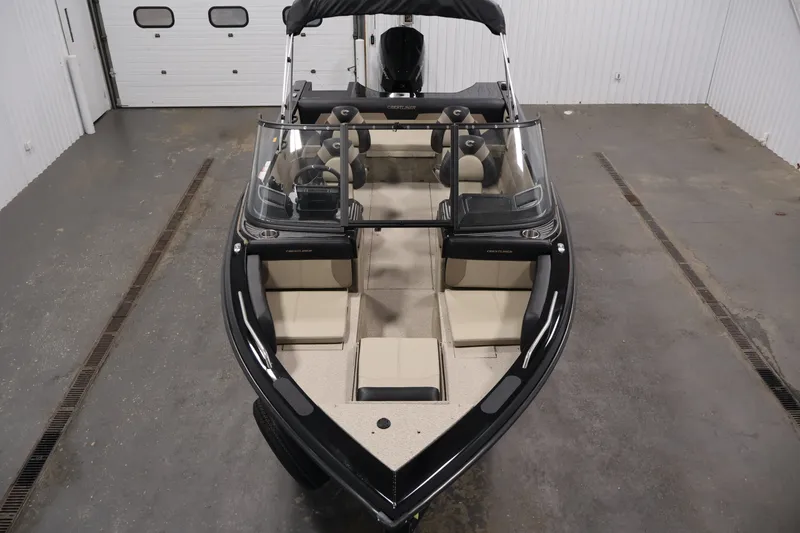 Slide: The Image of 2026 Crestliner 2050 Sportfish boat in a garage, showcasing sleek design and spacious interior. - 8