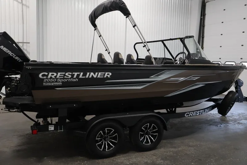 Slide: The Image of 2026 Crestliner 2050 Sportfish boat in a garage, featuring sleek design and trailer. - 7