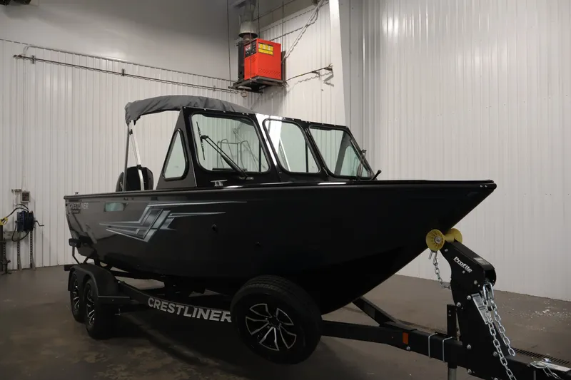 Slide: The Image of 2026 Crestliner 2050 Commander boat on trailer in indoor storage facility. - 2