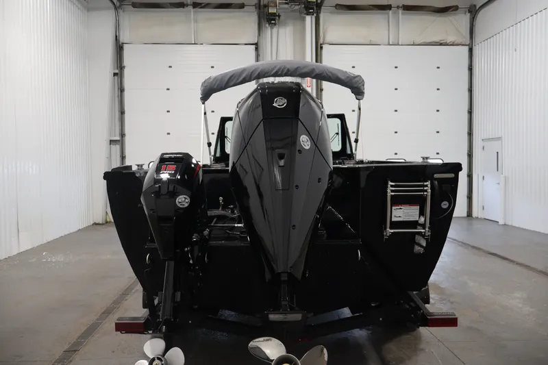 Slide: The Image of 2026 Crestliner 2050 Commander boat in a garage, rear view with dual outboard motors. - 5