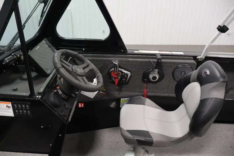 Slide: The Image of Interior of 2026 Crestliner 2050 Commander boat, featuring steering wheel and captain's chair. - 12
