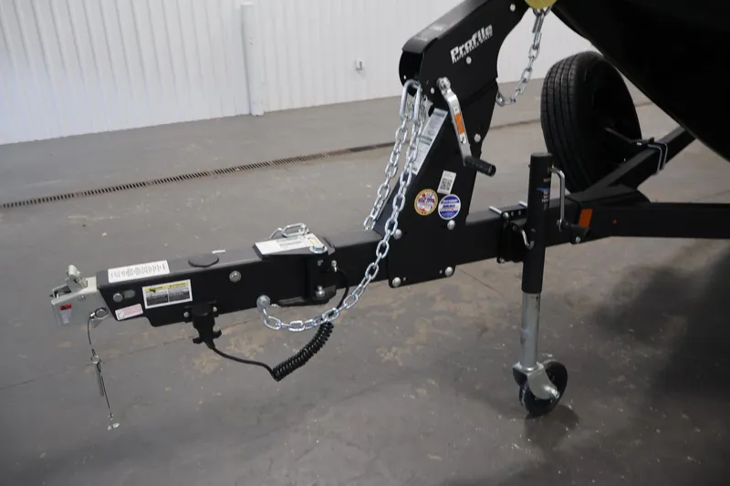 Slide: The Image of Trailer hitch of 2026 Crestliner 2050 Commander boat, featuring safety chains and wheel jack. - 35